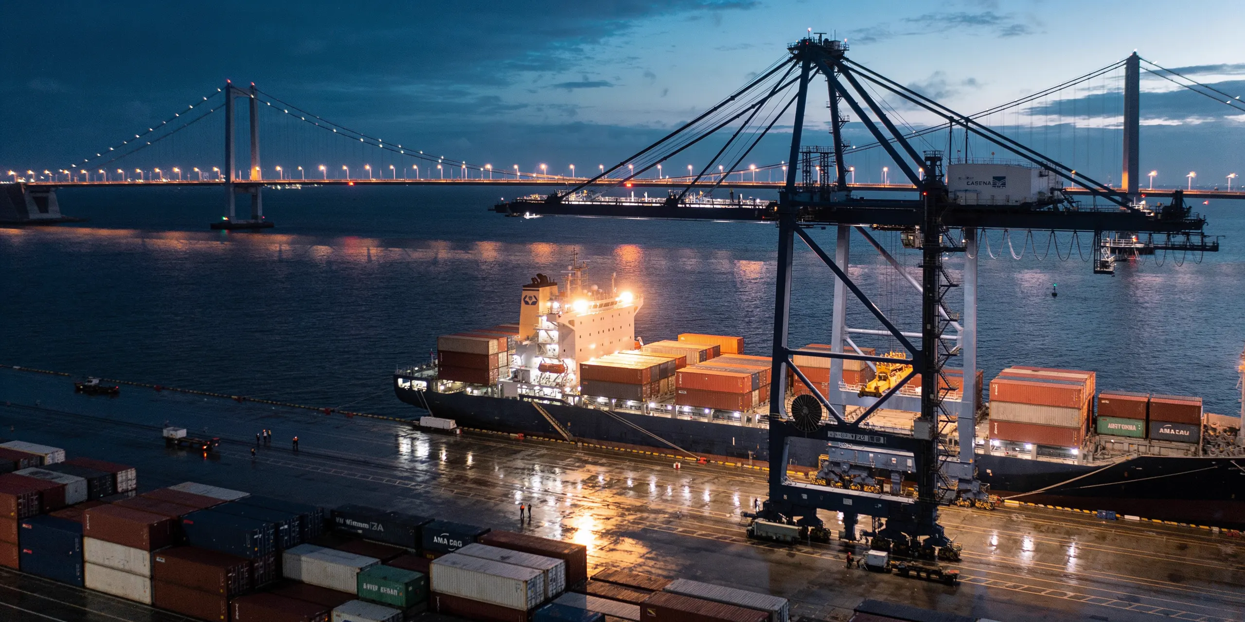 Container port at dusk with gantry cranes loading a cargo ship